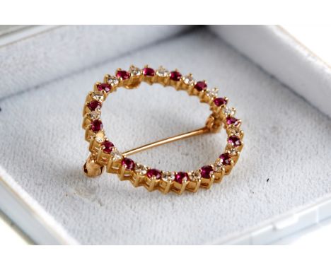 A 14K CIRCULAR YELLOW GOLD RUBY AND DIAMOND BROOCH, approximately 2.9 grams.   