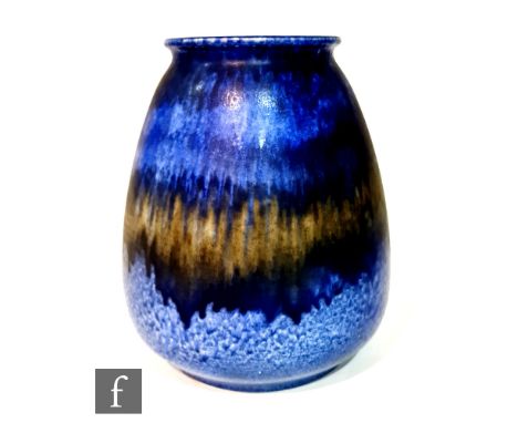 A large Ruskin Pottery barrel vase decorated in a dark blue dribble glaze with bands of glaze with a green central rim, impre