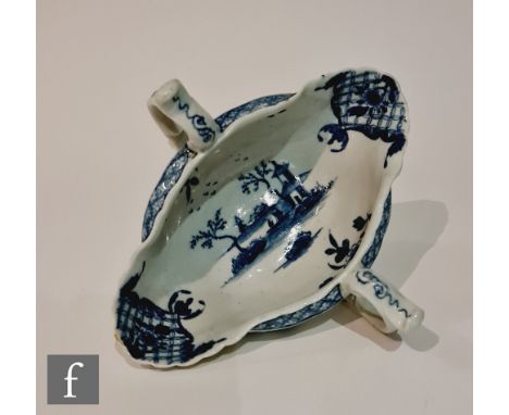 A late 18th Century Worcester twin handled sauce boat decorated with a blue and white hand painted landscape with smaller flo