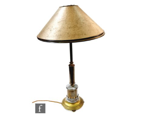 An Edwardian table lamp in patinated brass with applied pewter stiff leaf mounts to the stepped circular base, height 54cm. 
