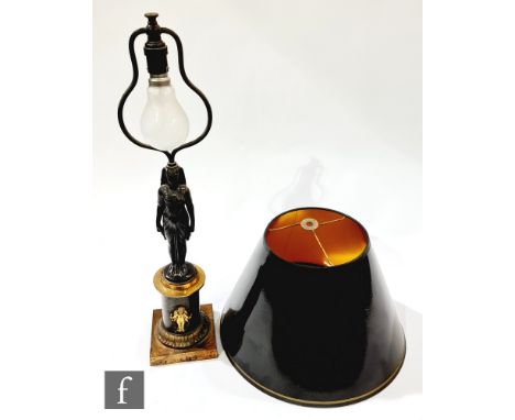 A French Empire style bronzed table lamp and shade, modelled as a Egyptian female standing on a square mount decorated with a