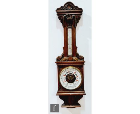 A late 19th Century carved oak barometer by F.J Gould Birmingham, incorporating a thermometer, with an eagle mount, height 10