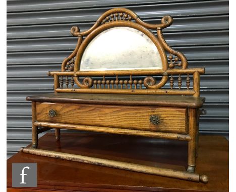 An Arts and Crafts wall hanging mirror bracket with a bobbin turned frieze above a glove box and rail, height 58cm, width 71c