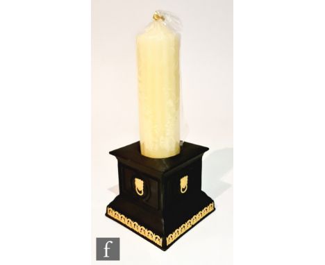 A later 20th Century Wedgwood candlestick, the square pillar body in black basalt with ochre lion head masks and running bord