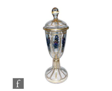 A Haida Bohemian lidded chalice, circa 1910, enamel decorated with stylised polychrome flowers in gilt borders, height 29cm. 