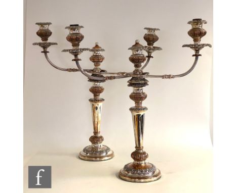A pair of silver plated on copper twin light candelabra, circular bases below plain flaring column and twin reeded arms and c