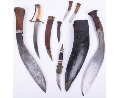 Gurkha Kukri, housed in its original leather covered scabbard with skinning knives. Wooden handle with metal cap to the top. 
