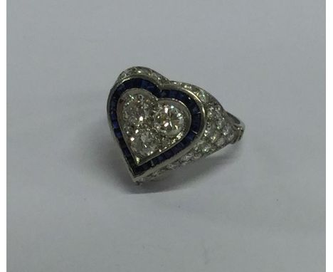 A large sapphire and diamond heart shaped ring in platinum mount. Approx. 4 grams. Est. £1200 - £1500.