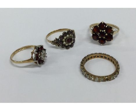 An Antique garnet and pearl ring together with three others set in gold. Approx. 10 grams. Est. £100 - £150.