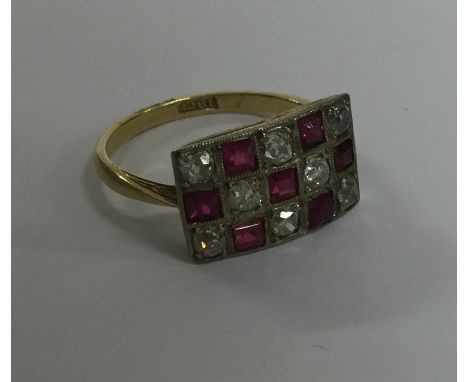 A ruby and diamond chequerboard ring in gold and platinum mount. Approx. 4 grams. Est. £500 - £800.