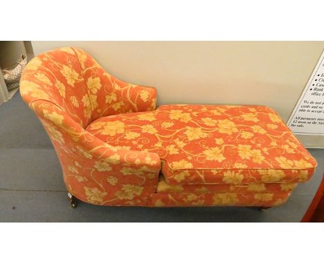A late 19th century chaise longue day bed having vine leaf designed upholstery, raised back rest over a loose cushion and sta