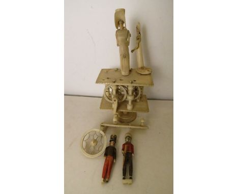 A Napoleonic prisoner of war bone automaton ornament, two tier construction with spinning wheel movement turned by a handle a