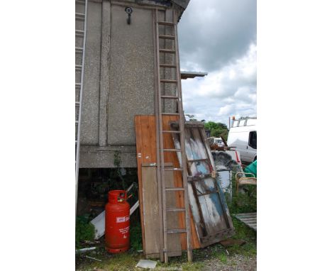 A thirteen rung wooden extension ladder.