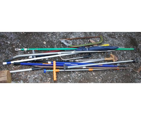 A quantity of garden tools, hoes, saws and walking sticks, etc.