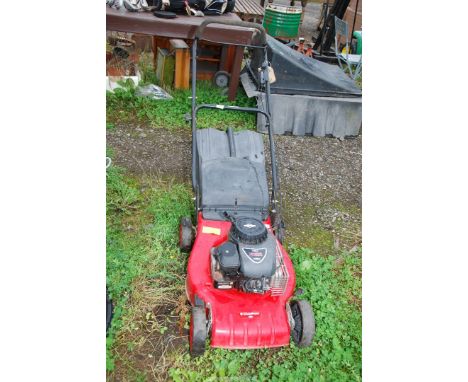 A Champion lawn mower with grass box, four strokes with Briggs and Stratton 148cc engine. (engine turns).