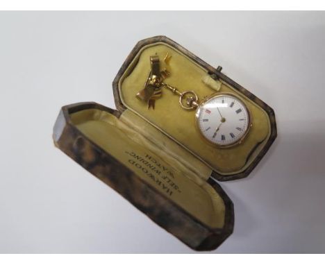 A 12ct gold ladies top wind watch on a 9ct gold brooch pin, the watch is 3cm wide with an enamel back and gold dust cover, th