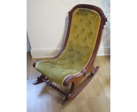 A late Victorian mahogany button back rocking chair in generally good condition 