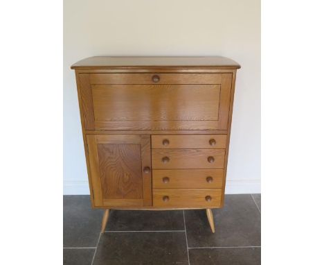 A light Elm Ercol cabinet with a fall front above four drawers and a cupboard, 117cm tall x 98cm x 48cm, in good condition ha