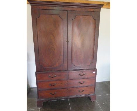 A Georgian mahogany linen press with four oak linen slides above two short and two long drawers on bracket feet having an int