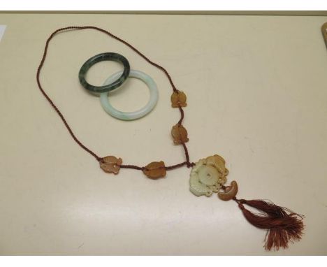 Two jade bangles, 8.5cm and 8cm diameter, and a carved pendant necklace, main pendant 5cm x 6cm, all good condition 