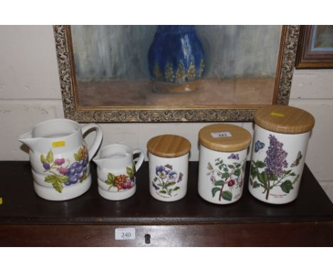 Three Portmeirion graduated storage jars and a pair of Melba jugs