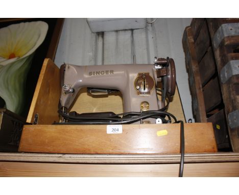 A Singer electric sewing machine in fitted case, sold as collectors item