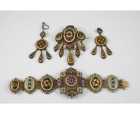 A CONTINENTAL GILT METAL AND ENAMEL SUITE OF JEWELLERY comprising a bracelet, 16cm. long, a brooch, 5cm. wide and a pair of d