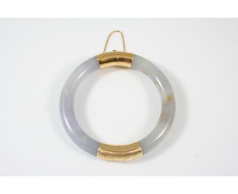 A LAVENDER JADE AND GOLD BANGLE with foliate engraved decoration set to the hinge and clasp.
