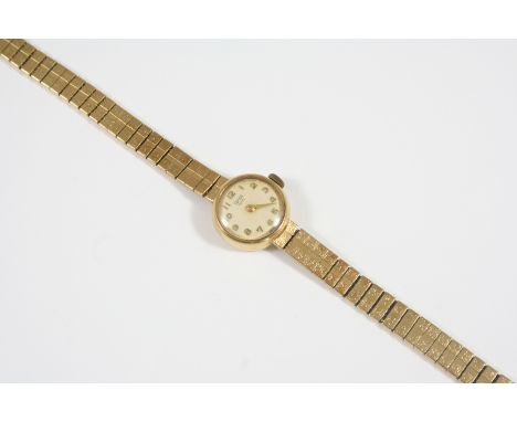 A LADY'S 9CT. GOLD WRISTWATCH BY TUDOR ROYAL the signed circular dial with Arabic numerals, on an integrated flexible gold br
