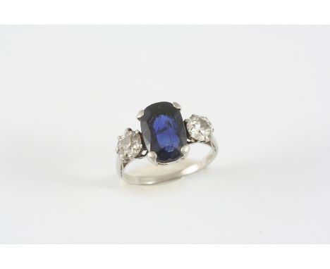 A SAPPHIRE AND DIAMOND THREE STONE RING the oval-shaped sapphire is set with two circular-cut diamonds. Size K 1/2.