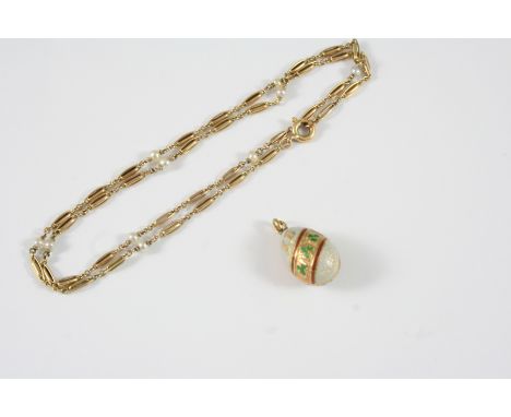 AN ENAMEL EGG PENDANT with red, green and pale blue enamel decoration depicting three leaf clovers and with the initials XB, 