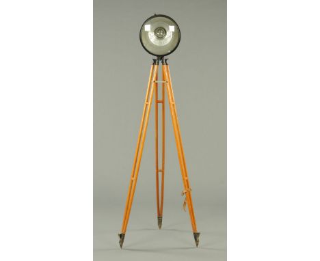 A circular spot lamp, raised on a wooden tripod base, probably a film lamp.  Diameter of lamp 35 cm, height of stand 165 cm.