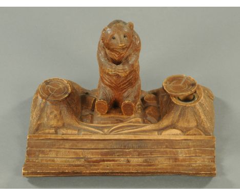 A 19th century Black Forest carved bear and tree trunk desk stand.  Width 32 cm. 