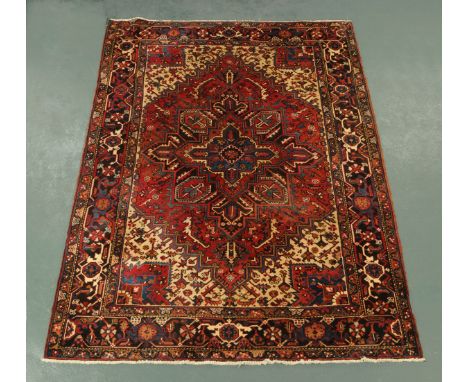 An Iranian woollen rug, fringed ends, principal colours dark blue, red, brown and beige.  282 cm x 213 cm (see illustration).