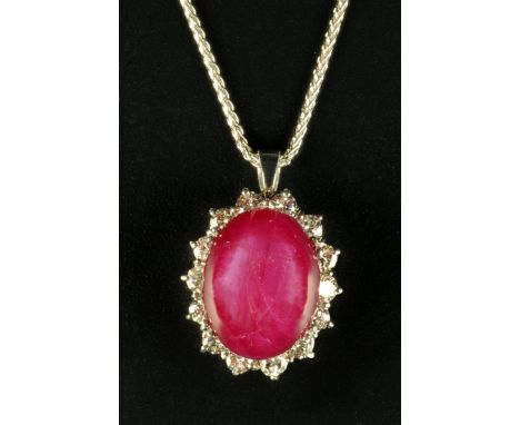 An 18 ct gold star ruby and diamond cluster pendant, ruby 10.55 carats, diamond weight 1 carat (see illustration).  
