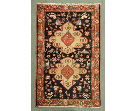 * An Iranian rug, with centre rectangular panel with two beige and iron red motifs and multiple line border.  134 cm x 203 cm