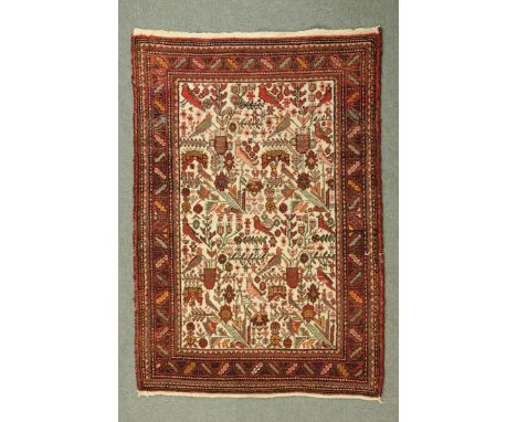 * An Iranian rug, the centre rectangular panel decorated with birds and foliate designs to beige ground and with multiple lin