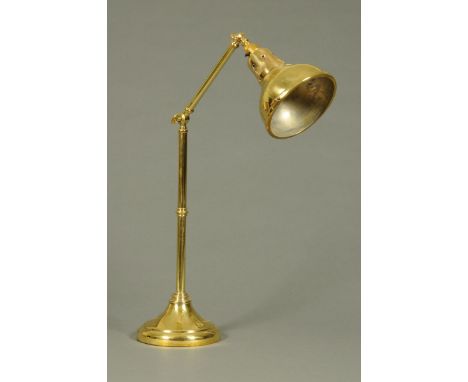 A brass desk lamp, with brass shade.