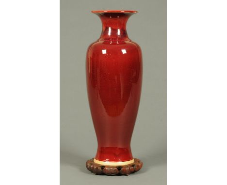 A Chinese Sang de Boeuf vase, with impressed marks and raised on a wooden stand.  Height excluding stand 50 cm.  CONDITION RE