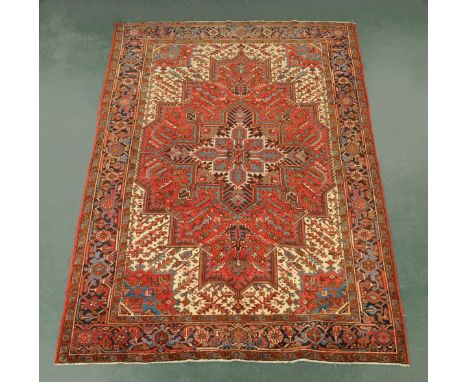 An Iranian woollen rug, fringed, principal colours red,beige and black.  300 cm x 213 cm (see illustration).
