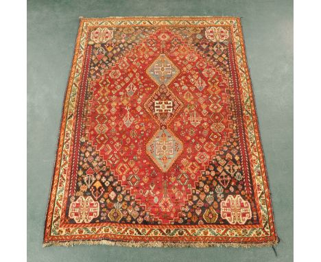 An Iranian woollen fringed rug, principal colours beige, red and blue.  246 cm x 181 cm (see illustration).