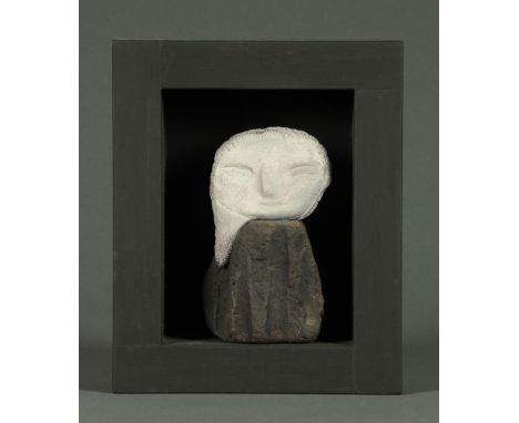 * Stylised figure, in wood surround, white head, dark body.  Figure height 14 cm. 