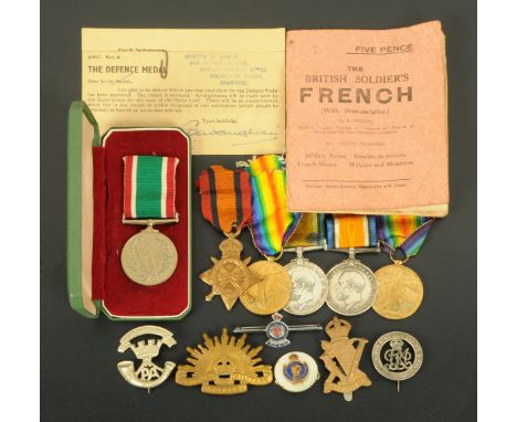 A collection of World War One medals, cap badges, Women's Volunteer Service medal, etc., contained within plastic box.   COND