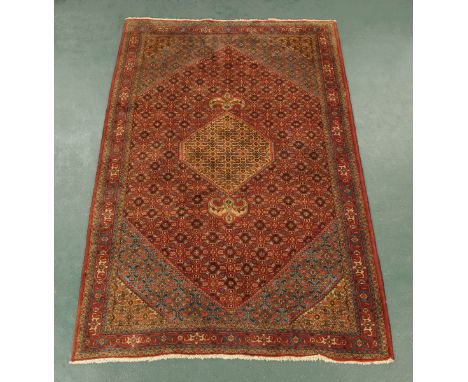 An Iranian woollen rug, principal colours beige, red and blue.  303 cm x 200 cm (see illustration).