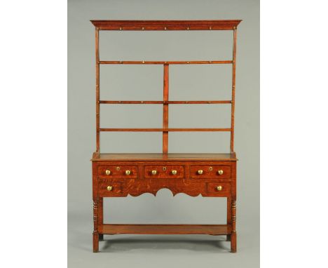 A 19th century oak dresser with Delft rack, the base fitted with a series of drawers with brass knob handles and cockbeading 