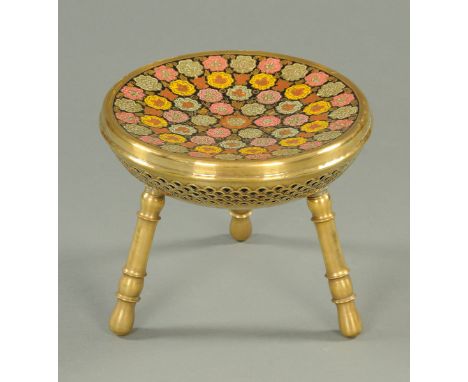 An Islamic stool, brass and enamel, with dished top and raised on three legs.  Diameter 31.5 cm. 