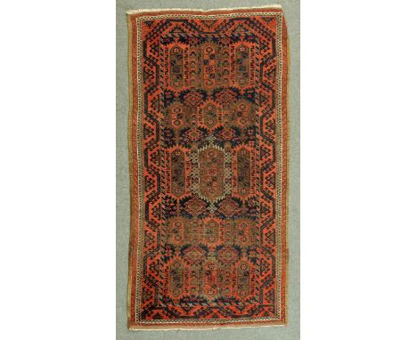 * A Persian rug, with red ground, decorated in dark blue and beige and with repeating line border.  108 cm x 202 cm. 