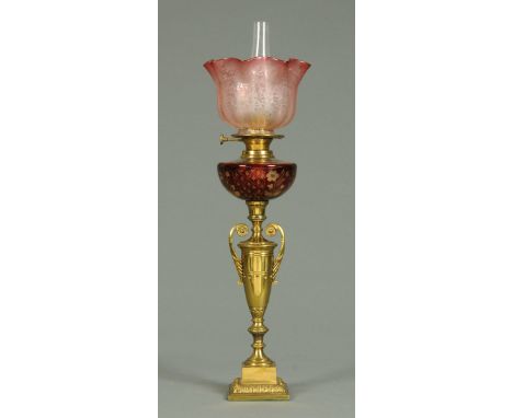 A Victorian brass and glass oil lamp, slim form, with etched cranberry glass shade and reservoir.  Overall height 62 cm (see 