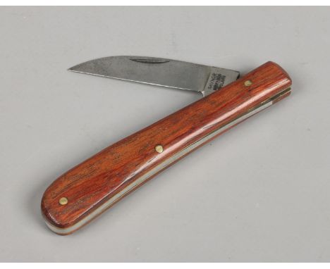 A folding pruning knife by maker Saynor of Sheffield and with hardwood scales.