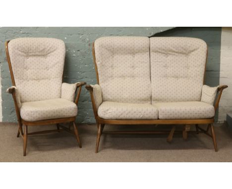 An Ercol Golden Dawn upholstered spindle back two seat sofa and matching arm chair in need of restoration.